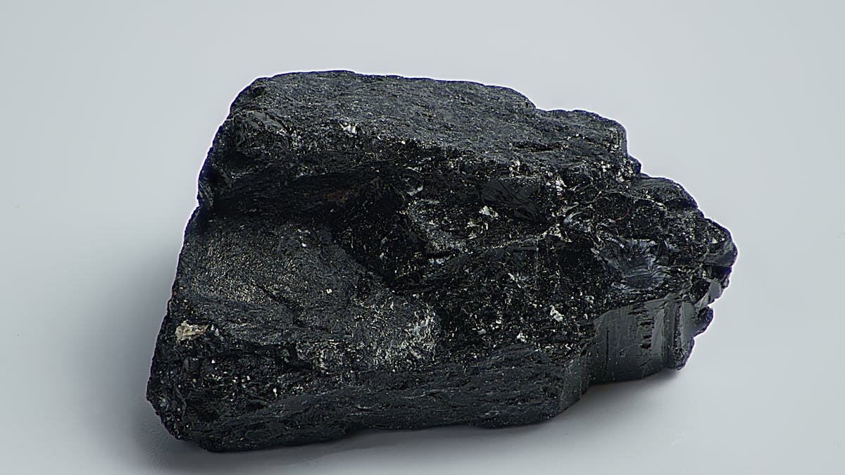 Detailed macro shot of a dark mineral rock specimen on a plain surface